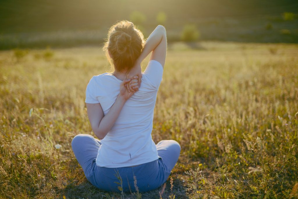 woman practices yoga and meditates in the lotus position on the nature.